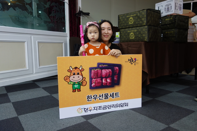 경품추첨에서 한우선물세트를 받은 기자 가족이 즐거워하고 있다. 