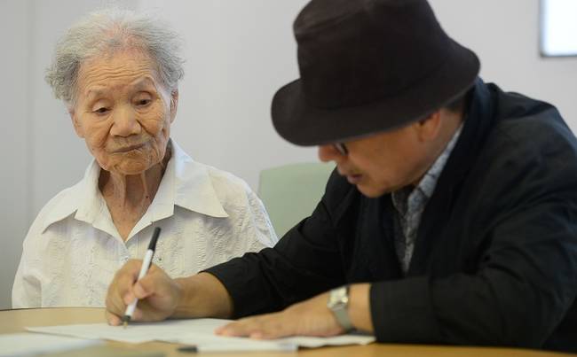 지난달 27일 오후 서울 중구 대한적십자사 본사 이산가족민원실에서 김의순(97) 할머니와 아들 김진관 할아버지가 이산가족찾기 신청서를 작성하고 있다. (뉴시스)