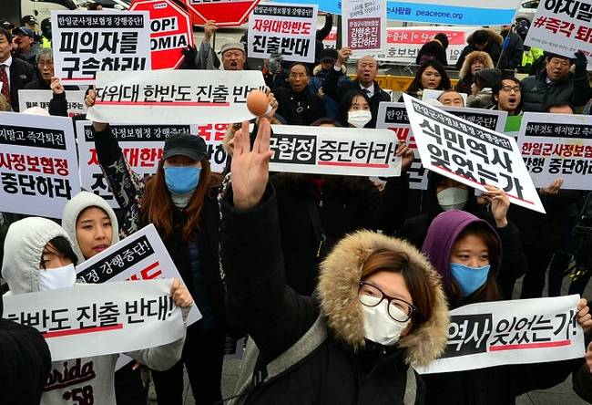 22일 서울 종로구 정부서울청사 앞에서 한일 일본군'위안부'합의 무효를 위한 대학생대책위원회, 사드저지전국행동, 전쟁반대평화실현국민행동 등 시민사회단체들이 주최한 한일군사정보보호협정 국무회의 의결중단, 대통령 재가 반대 기자회견에서 참가자들이 피켓을 들고 구호를 외치며 계란을 던지고 있다.(뉴시스)