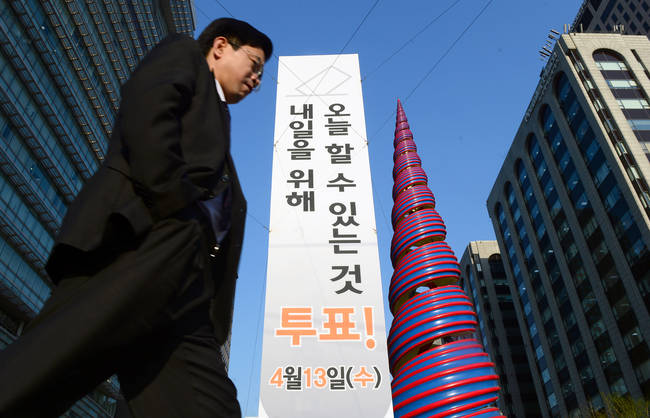 조기 대선을 앞두고 선거연령을 현행 만 19세에서 만 17~18세로 낮추자는 목소리가 고개를 들고 있다. 사진은 지난해 4.13 총선을 이틀 앞둔 11일 오후 서울 종로구 청계광장에 설치된 투표 독려 입간판 앞을 시민이 지나는 모습. (뉴시스)