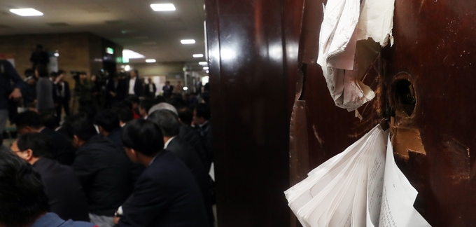 선거제 개편안과 사법제도 개혁안의 패스트트랙 지정을 놓고 여야의 극한 대치가 이어진 지난달 26일 새벽 국회 의안과 파손된 출입문 앞에서 자유한국당 의원들이 긴급 의원총회를 하고 있다. /뉴시스 선거제 개편안과 사법제도 개혁안의 패스트트랙 지정을 놓고 여야의 극한 대치가 이어진 지난달 26일 새벽 국회 의안과 파손된 출입문 앞에서 자유한국당 의원들이 긴급 의원총회를 하고 있다. /뉴시스