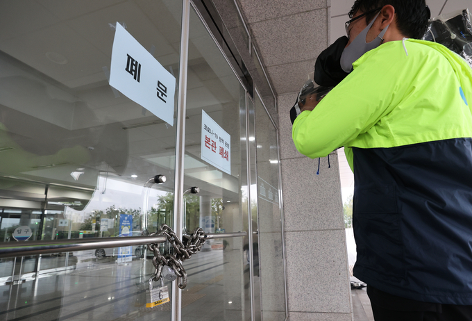 국회 출입기자의 신종 코로나바이러스 감염증(코로나19) 확진 판정으로 27일 오전 국회 본관이 폐쇄된 가운데 출입구 앞에서 한 취재진이 촬영하고 있다. /연합뉴스 국회 출입기자의 신종 코로나바이러스 감염증(코로나19) 확진 판정으로 27일 오전 국회 본관이 폐쇄된 가운데 출입구 앞에서 한 취재진이 촬영하고 있다. /연합뉴스