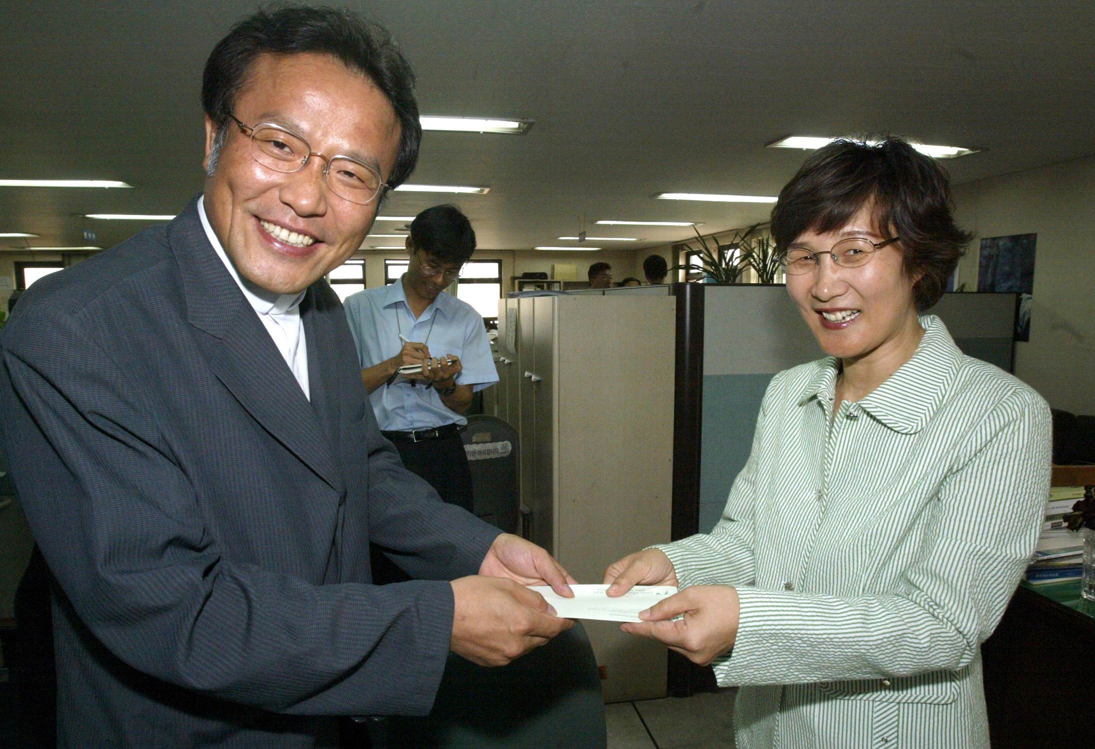 '밥퍼나눔운동본부' 대표인 최일도 목사가 지난 20일 권태선 편집국장에게 발전기금 5백2만원을 전달하고 있다.