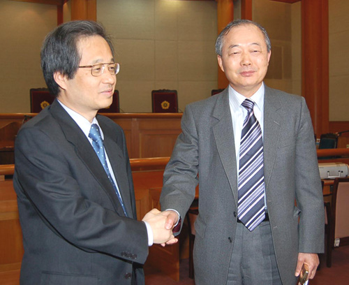 신문법 및 언론중재법 위헌 소송에 관한 2차 변론에 앞서 문화부측 참고인인 신문발전위원회 장행훈 위원장(오른쪽)과 동아·조선측 참고인인 숭실대 강경근 교수가 악수를 나누고 있다.