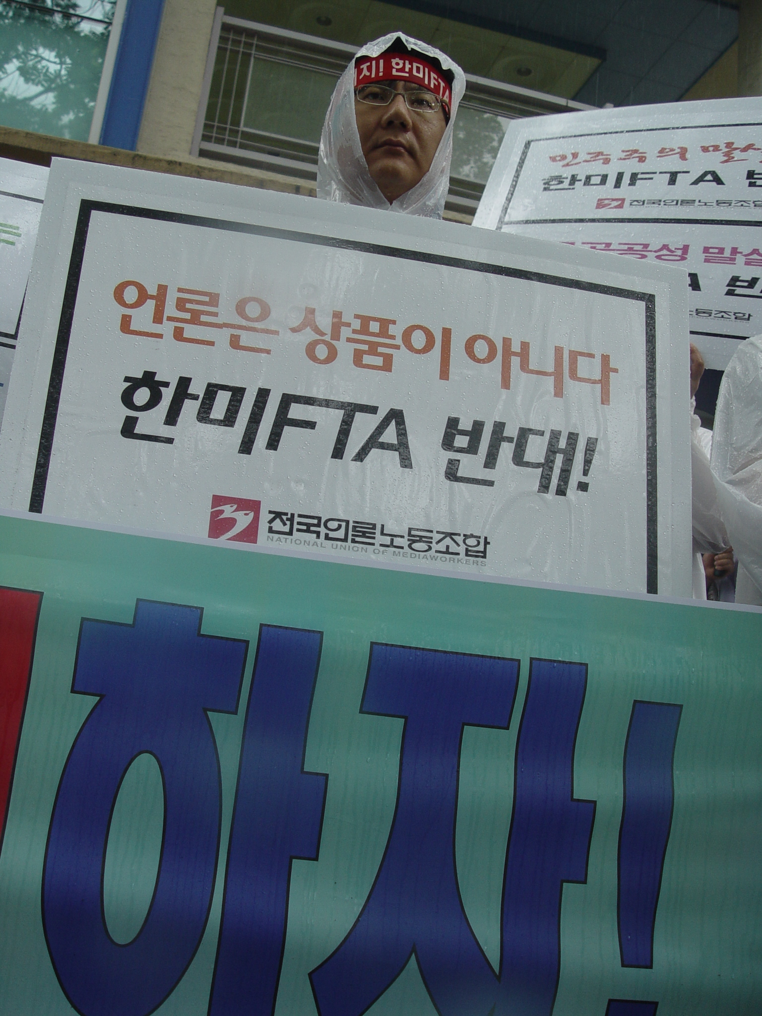 기자회견장에서 한 조합원이 한미FTA를 반대하는 피켓 시위를 벌이고 있다.